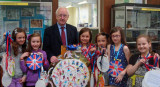 Children with MP, holding gold medal artwork.