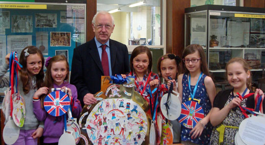 Children with MP, holding gold medal artwork.