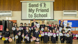 Group of children holding up a long banner of gold medal artwork