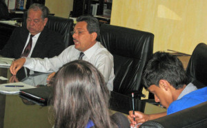 Young Ambassadors in an office, listening to two older men