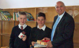 Man with two boys presenting him with artwork