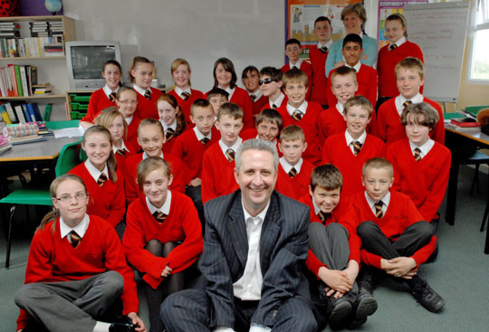 Man seated on the floor with group of schoolchildren