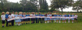 Long line of children holding up scarf artwork