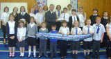 Adults with children displaying a scarf banner