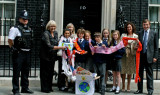 Children and teachers with a giant scarf on doorstep of 10 Downing Street