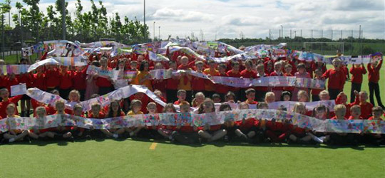 Large group of schoolchildren holding up banners