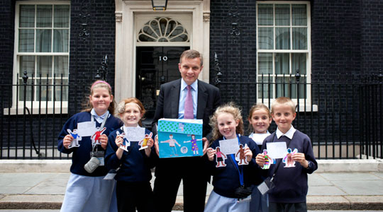 Man and schoolchildren with artwork outside 10 Downing Street