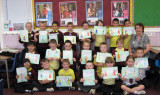 Children holding up artwork