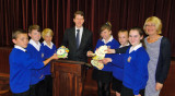 Children and teacher present MP with gold medal artwork.